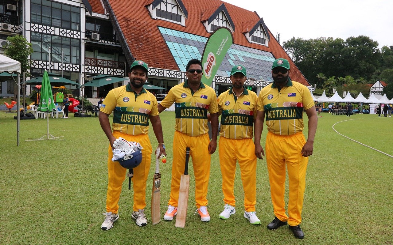 Four Australian cricket players holding bats on a cricket ground